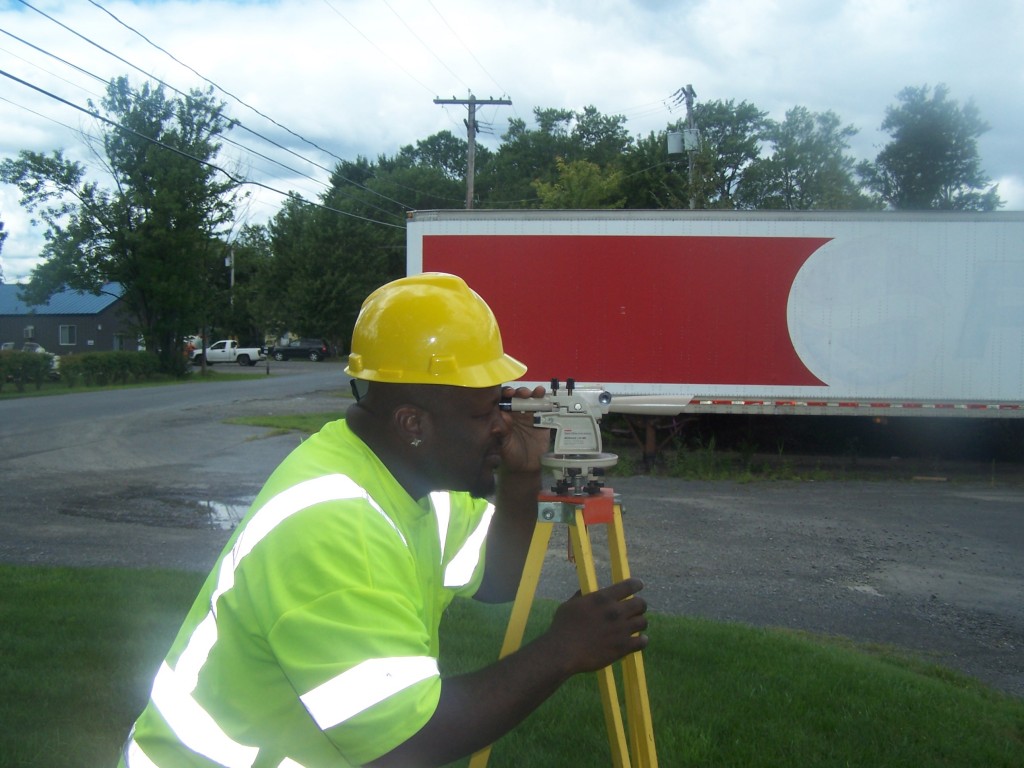 Construction apprentice Marcus Davis using a transit level. 